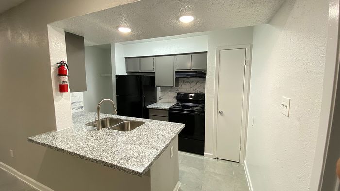 Modern kitchen featuring sleek granite countertops, stylish cabinetry, and contemporary appliances.