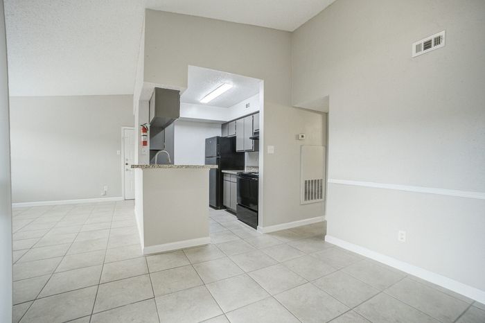 Bright and welcoming open-concept kitchen featuring sleek granite countertops, modern appliances, and elegant tile flooring.