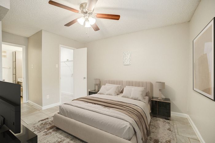 Elegant bedroom with cozy double bed, modern furniture, ceiling fan, and ample natural light.