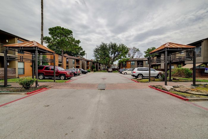 Charming apartment complex with modern outdoor design, offering convenient parking and landscaped greenery.