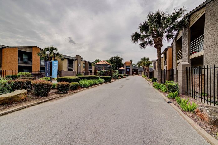 Inviting apartment complex with lush landscaping, palm trees, and a resort-style ambiance perfect for serene living.
