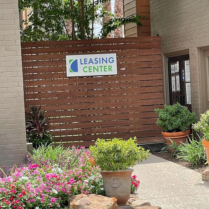 Welcoming leasing center surrounded by vibrant flowers and lush greenery, creating a serene entrance.