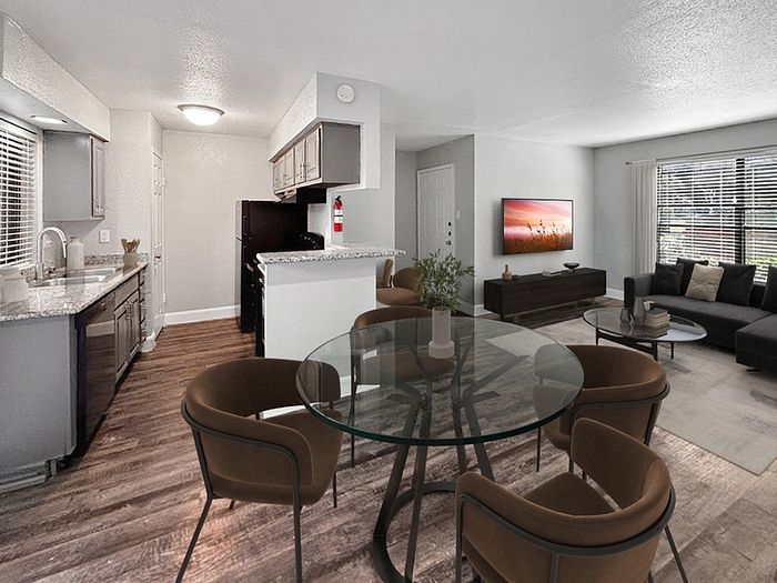 Modern open-plan apartment showcasing a sleek kitchen with granite countertops, elegant dining area, and cozy living room with large window.