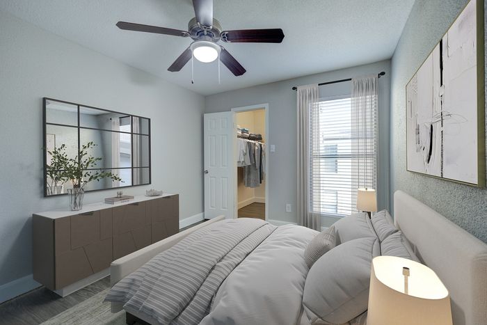 Bright and inviting bedroom featuring elegant decor, a plush bed, modern ceiling fan, and a spacious walk-in closet.