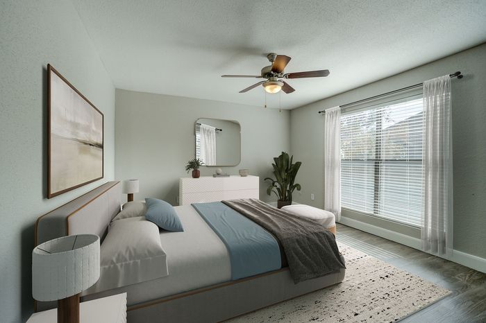 Elegant and airy bedroom with modern decor, featuring a cozy bed, stylish ceiling fan, large windows with drapes, and soothing natural light.