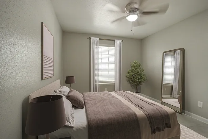 Cozy bedroom with elegant decor, featuring a large mirror, plush bedding, and natural light from a window with sheer curtains.