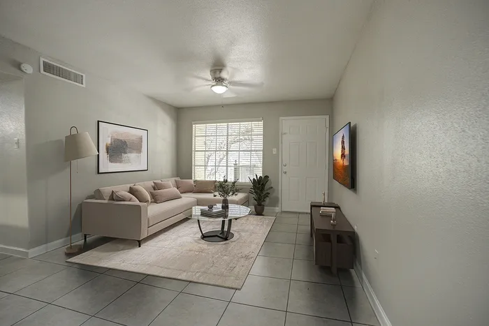 Inviting living room featuring a cozy sectional sofa, modern decor, and ample natural light from a large window.