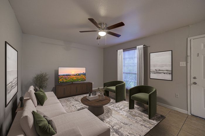 Cozy living room with elegant neutral tones, featuring a plush sofa, modern green armchairs, and a large TV on a wooden stand. Natural light floods through a window with white curtains, highlighting abstract wall art.