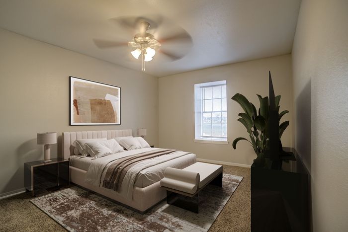 Inviting bedroom with a plush bed, elegant side tables, and a cozy ambiance enhanced by a ceiling fan and natural light from a large window.