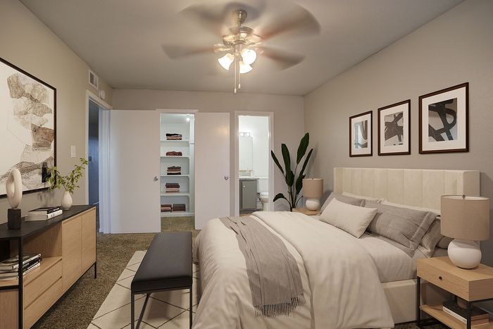 Elegant bedroom featuring a cozy bed, stylish artwork, modern furniture, and spacious built-in shelving.