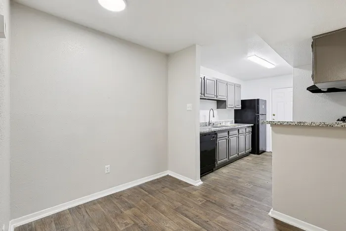 Bright kitchen with modern gray cabinetry, sleek granite countertops, and elegant wood flooring.