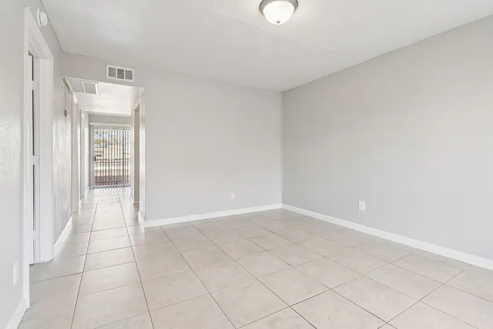 Bright and inviting apartment with sleek tiled flooring, offering ample space and natural light.