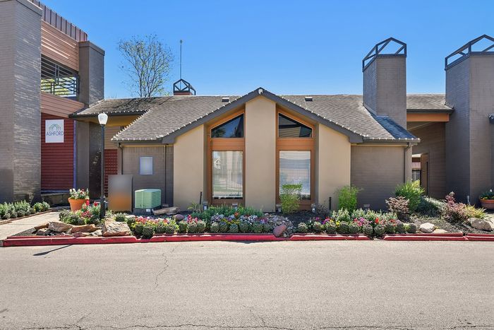 Charming modern apartment exterior with a beautifully landscaped garden and unique architectural features.