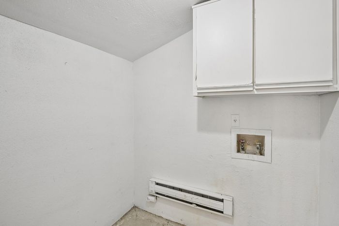 Charming utility room with elegant white cabinetry, perfect for storage solutions and optimizing space.