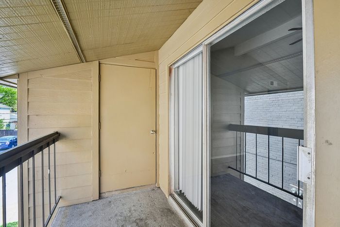 Charming apartment balcony with sliding glass doors and cozy outdoor space.