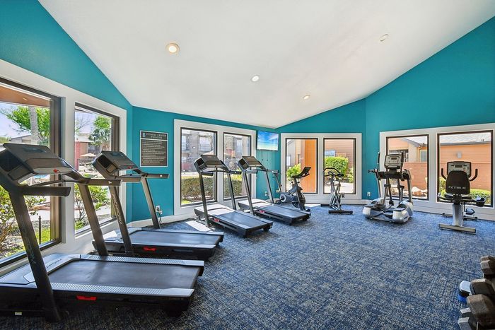 Bright and modern fitness center with state-of-the-art treadmills and cardio equipment, offering a vibrant and inviting workout space.