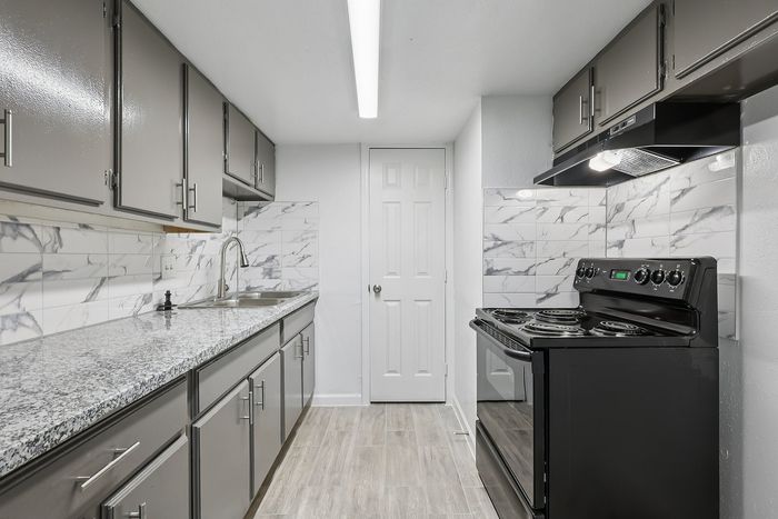 Contemporary kitchen with sleek granite countertops, modern cabinetry, and elegant marble backsplash.