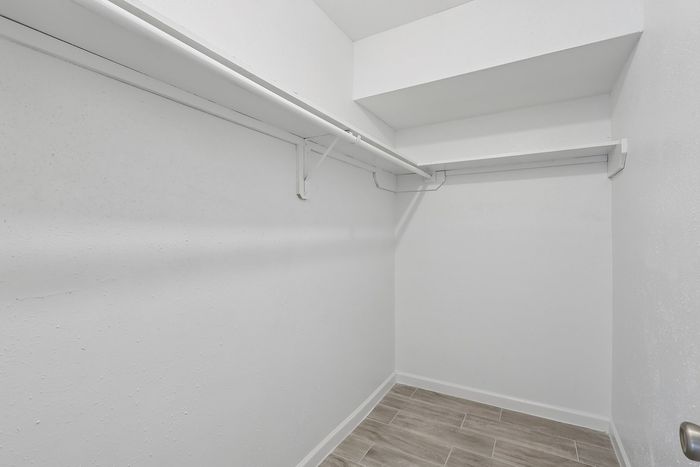 Bright, spacious walk-in closet with ample shelving and elegant tiled flooring, perfect for organized living.