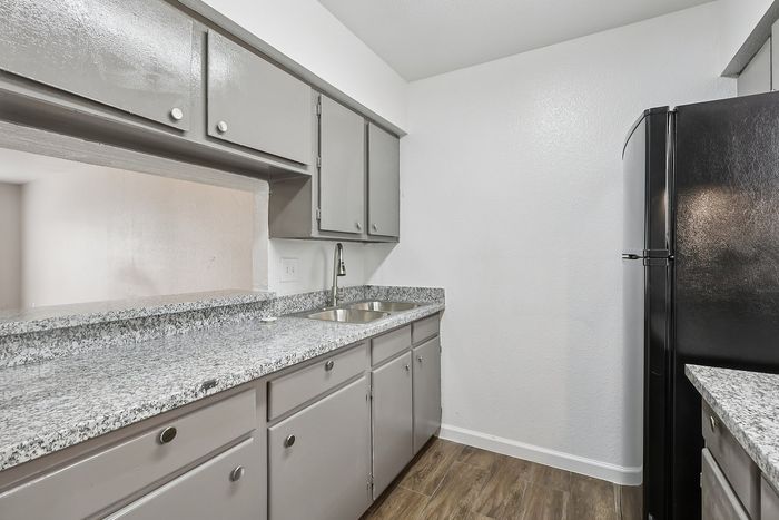 Chic kitchen with sleek granite countertops, modern stainless-steel sink, and elegant cabinetry, offering a stylish and functional space.