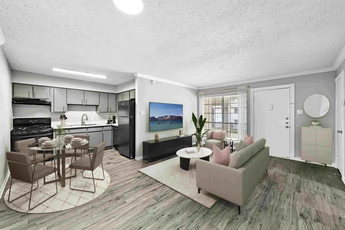 Modern open-plan living space featuring a stylish kitchen with sleek cabinetry and a cozy living area with plush sofas and a large window for natural light.