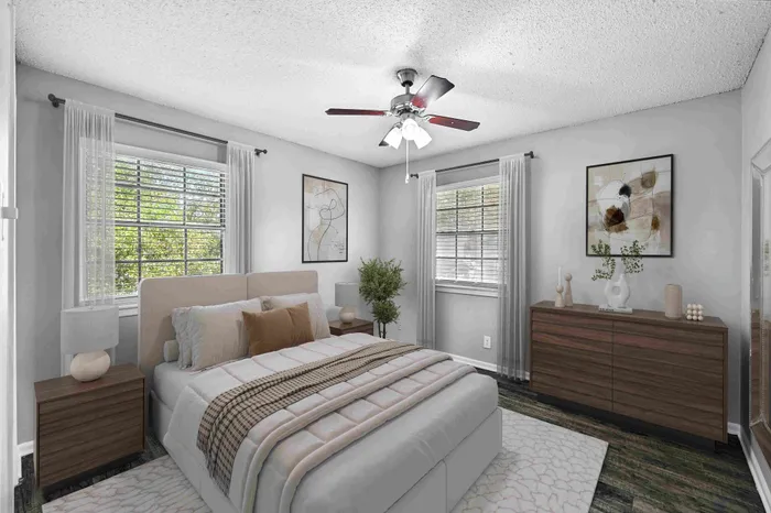 Inviting bedroom with elegant decor, featuring a plush bed, stylish artwork, and abundant natural light through large windows.