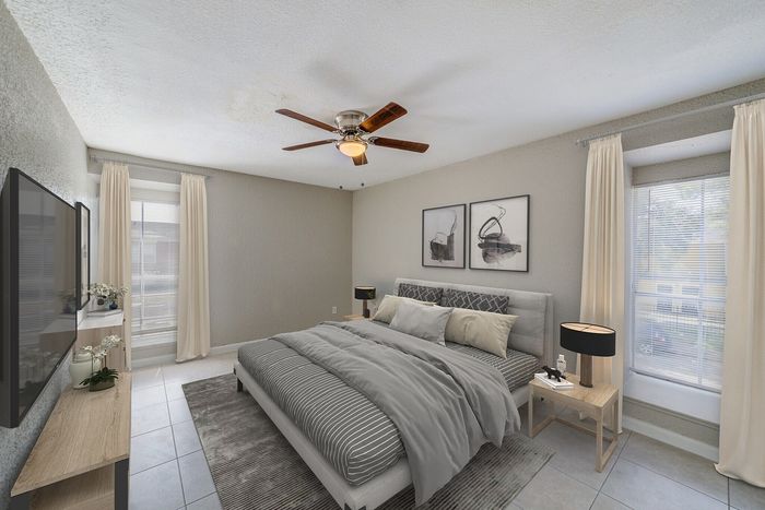 Inviting bedroom featuring elegant decor, contemporary furnishings, and ample natural light through large windows.