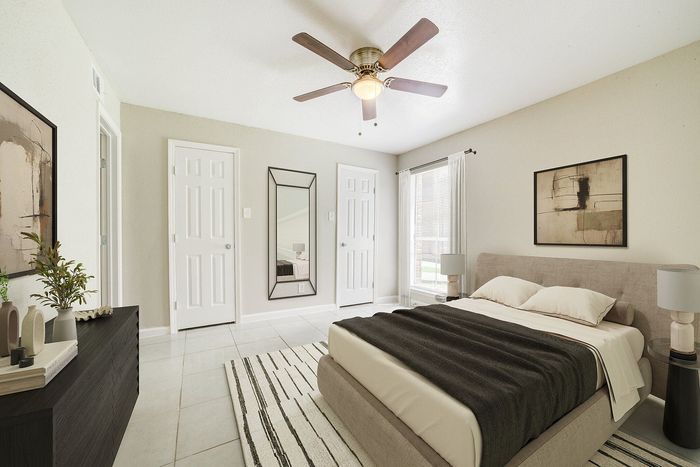 Bright and modern bedroom featuring a cozy upholstered bed, chic decor, and ample natural light.