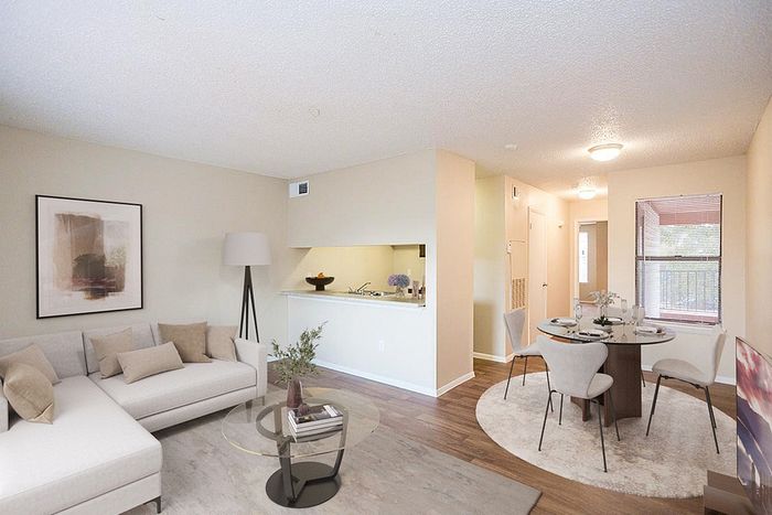 Elegant open-concept living room and dining area with cozy furnishings, natural light, and a chic modern design.