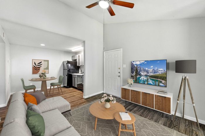 Contemporary living room with open layout, featuring stylish decor, cozy seating, and modern dining area adjacent to a sleek kitchen.