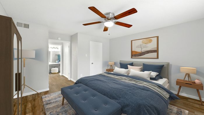 Inviting bedroom with modern decor, featuring a plush bed, stylish ceiling fan, and cozy lighting, offering a relaxing retreat.