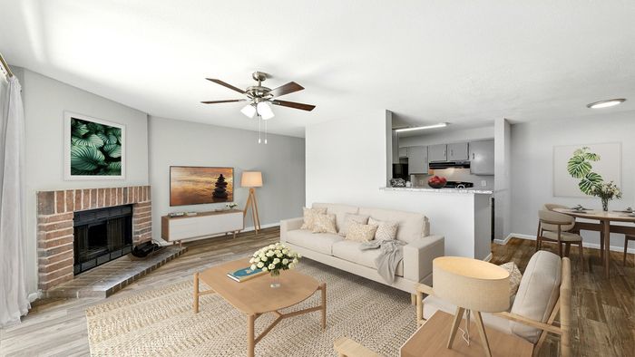 Inviting living room with modern decor, cozy fireplace, and open kitchen, ideal for relaxed living and entertaining.