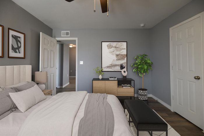 Inviting bedroom showcasing modern decor, comfortable bedding, elegant artwork, and a stylish dresser accentuated by natural light.