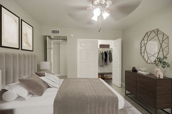 Inviting bedroom with elegant decor, featuring a cozy bed, modern dresser, and spacious open closet with ample storage.