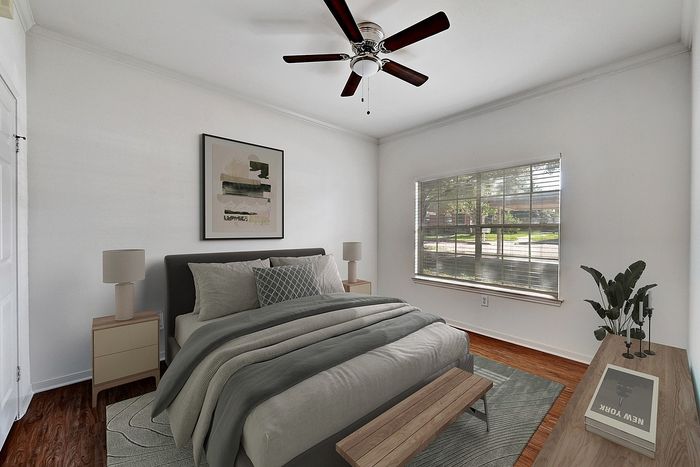 Inviting bedroom with a cozy bed, stylish artwork, and abundant natural light from a large window, creating a serene atmosphere.