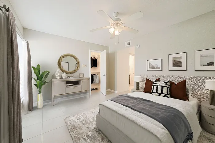 Elegant bedroom with chic decor, featuring a plush bed, stylish dresser with mirror, and cozy walk-in closet.