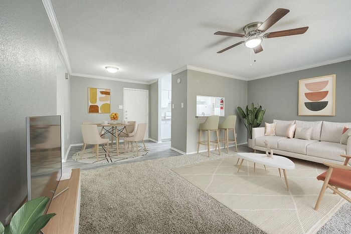 Modern living room with elegant decor, featuring a cozy sofa, stylish dining area, and sleek kitchen bar, perfect for entertaining.