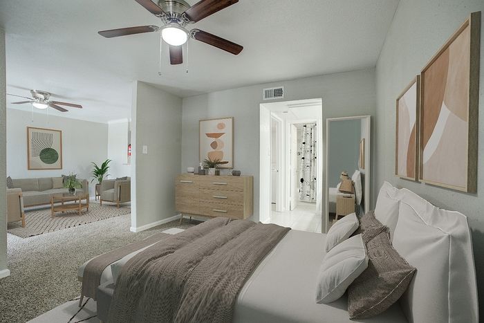 Chic apartment interior showcasing a cozy bedroom with stylish decor, leading into a spacious open-plan living area adorned with modern furnishings and natural light.