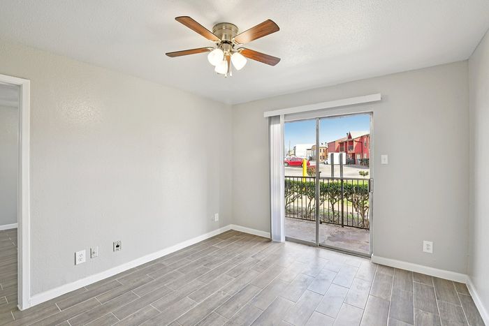 Bright room with elegant tile flooring, ceiling fan, and sliding glass door leading to a scenic outdoor view.