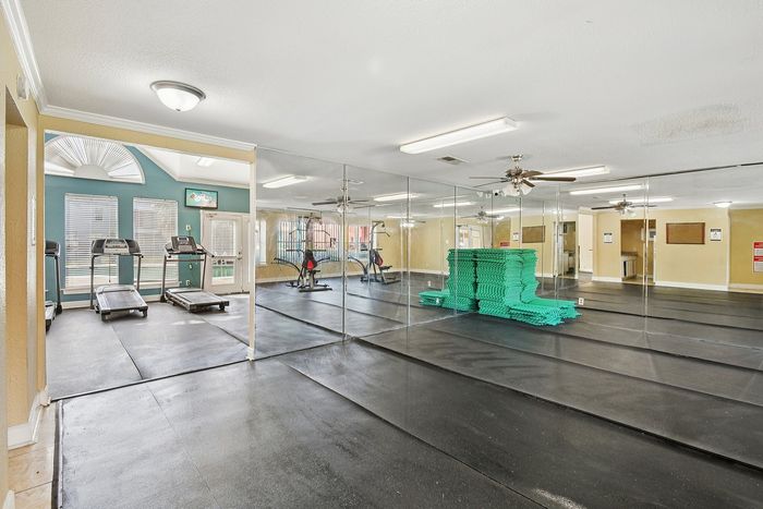Bright and spacious fitness center with mirrored walls, treadmills, and exercise equipment, perfect for active lifestyles.