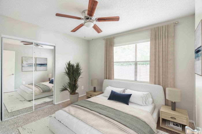 Bright and cozy bedroom featuring a comfortable bed, mirrored closet doors, and modern decor for a serene retreat.