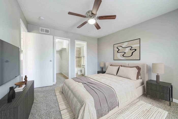 Elegant bedroom featuring a cozy bed with stylish linens, modern ceiling fan, and spacious walk-in closet.