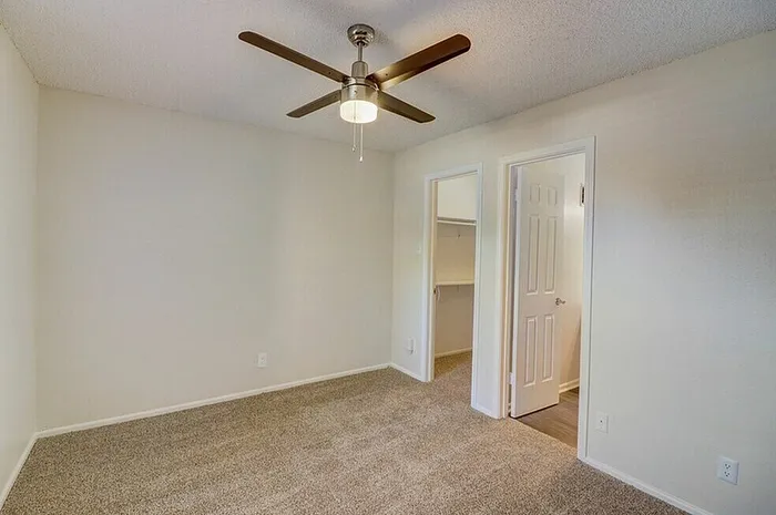 B1 primary bedroom with window and ceiling fan