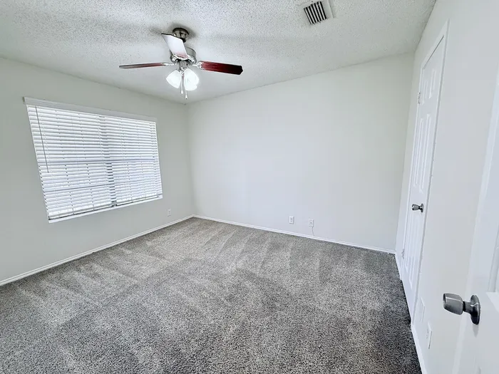 C1 primary bedroom with window and ceiling fan