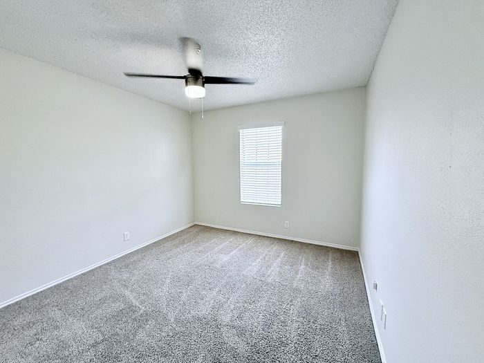 C1 second bedroom with window and ceiling fan