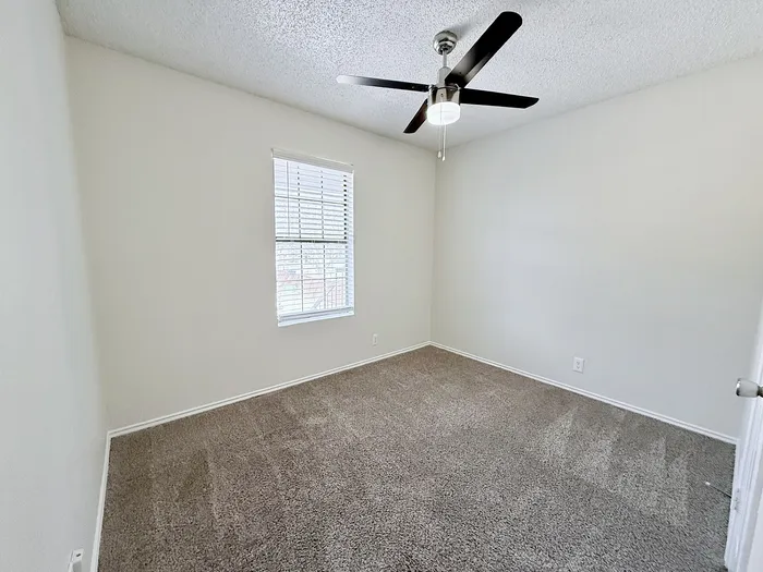 C1 third bedroom with window and ceiling fan