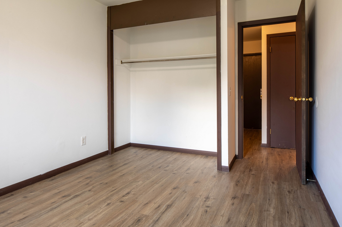 Bright, spacious room with elegant wood flooring and a built-in closet, perfect for stylish living.