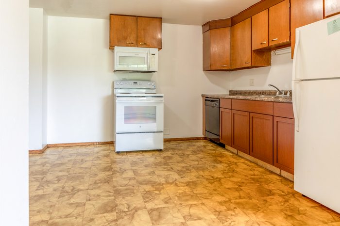 Inviting kitchen with hardwood cabinets, modern appliances, and spacious countertops for an ideal culinary experience.
