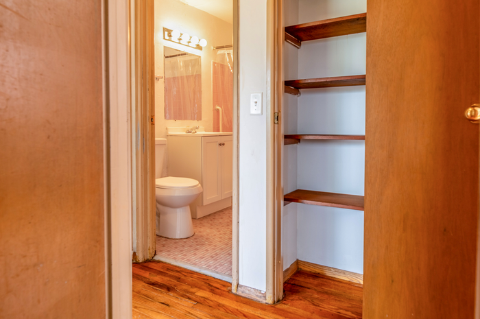 Inviting bathroom with charming tiles and warm wood shelving, perfect for cozy living.