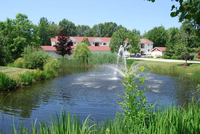Pond with fountain at Liv Wildwood apartments in Ludington, Michigan.