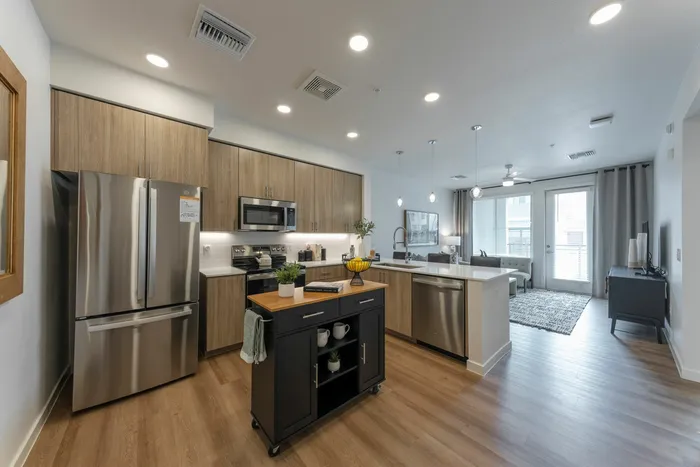 One-Bedroom Senior Apartments In Phoenix, AZ - Liv+ Union Peak - Gourmet Kitchen With Under-Cabinet Lighting, Quartz Countertops, And Stainless Steel Appliances.